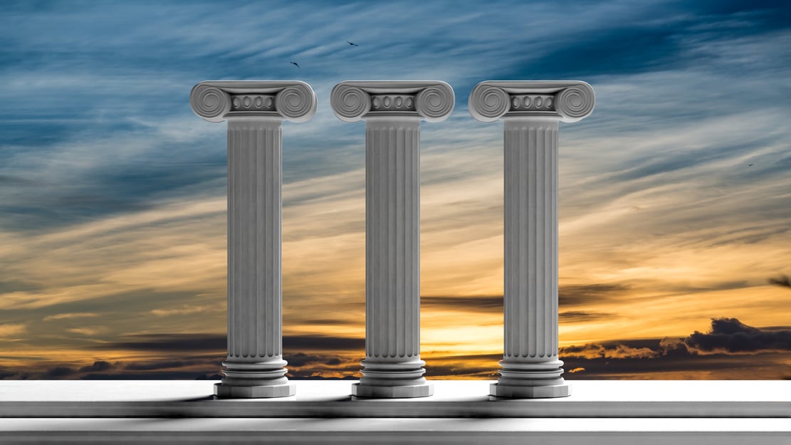 Three ancient pillars with sunset sky background.